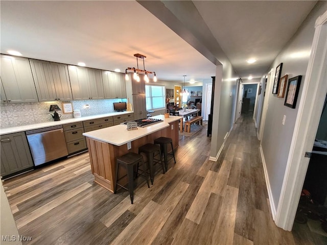 145 Maplewood Ave, Rittman, OH 44270 - kitchen with backsplash, a center island, light countertops, wood finished floors, and stainless steel dishwasher