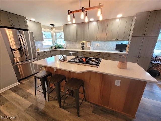 145 Maplewood Ave, Rittman, OH 44270 - kitchen with gray cabinetry, a kitchen island, decorative backsplash, appliances with stainless steel finishes, and dark wood-style floors