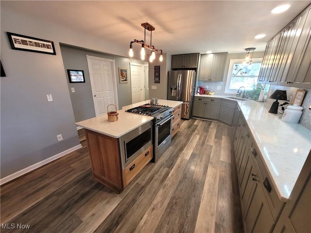 145 Maplewood Ave, Rittman, OH 44270 - kitchen featuring dark wood-style flooring, stainless steel appliances, decorative backsplash, light countertops, and pendant lighting