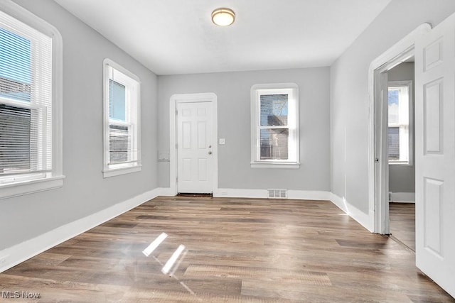 foyer with plenty of natural light, wood finished floors, and visible vents