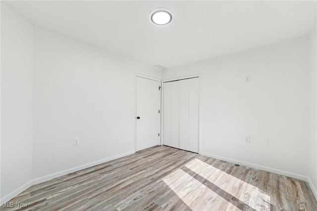 unfurnished room featuring wood finished floors and baseboards