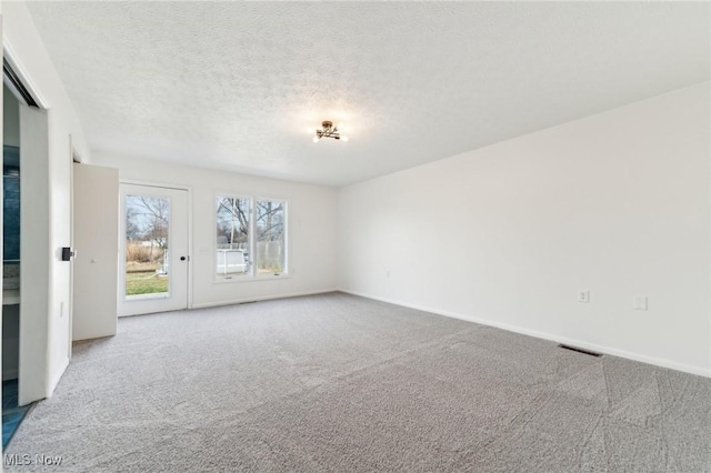 carpeted empty room featuring baseboards and a textured ceiling