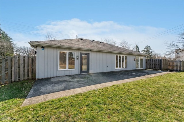 rear view of house featuring a patio area, a lawn, and fence