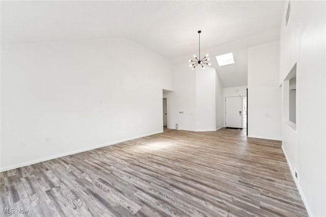 interior space with wood finished floors, high vaulted ceiling, an inviting chandelier, and a skylight