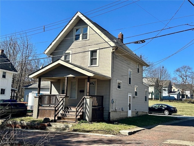 american foursquare style home with covered porch and a chimney