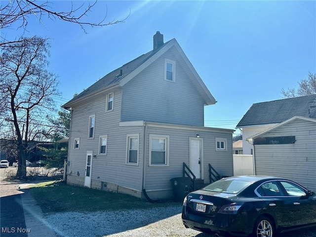 view of home's exterior with entry steps and a chimney