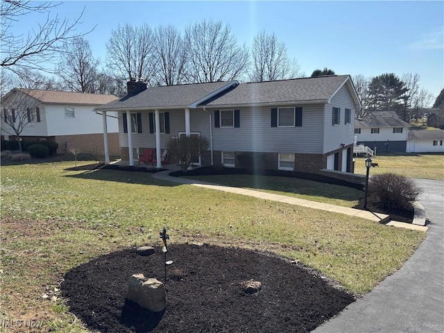 view of front of property featuring a front lawn, a garage, and a chimney