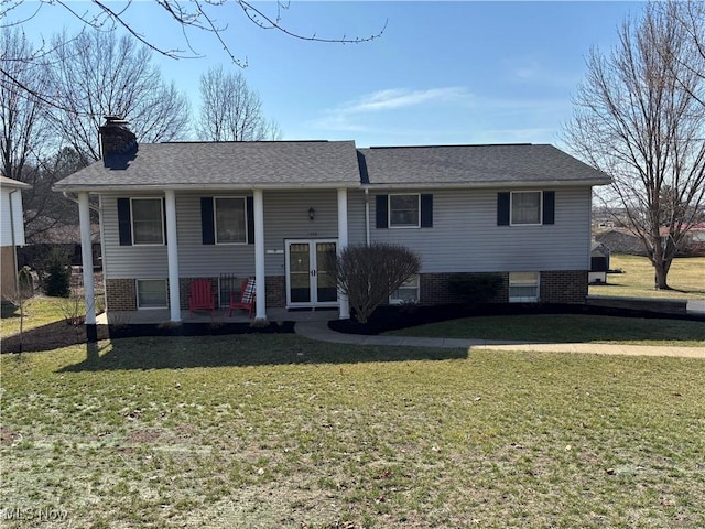 bi-level home with a shingled roof, a front yard, french doors, and a chimney