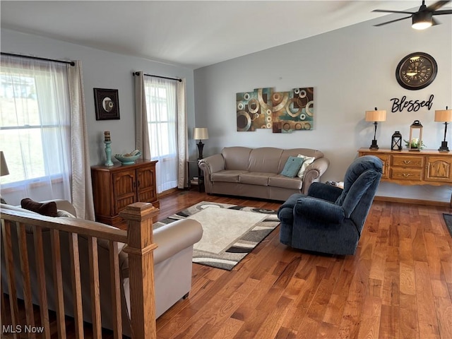 living area with ceiling fan, lofted ceiling, and wood finished floors
