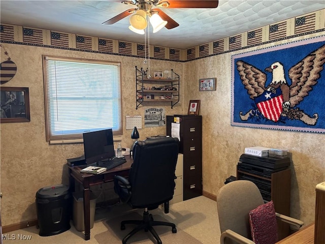 carpeted home office featuring ceiling fan