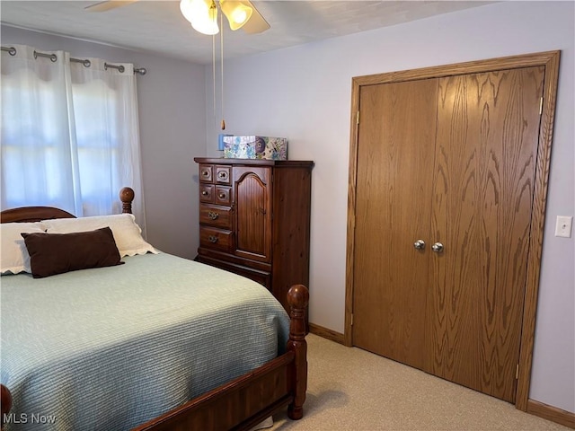 bedroom with light colored carpet, baseboards, and a ceiling fan