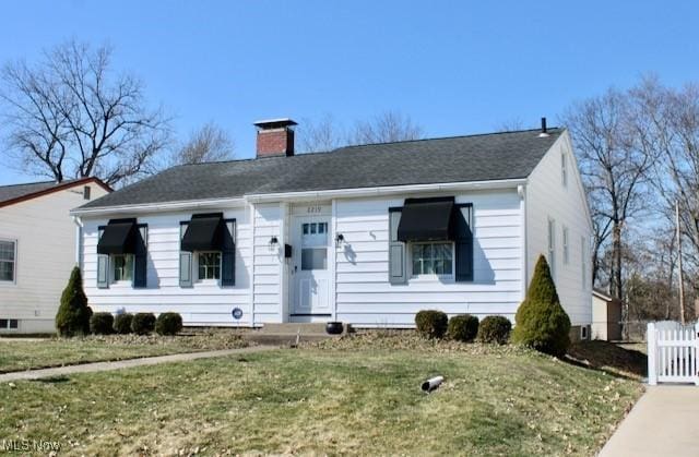 view of front of house with a front lawn, fence, and a chimney