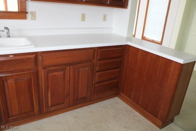 kitchen with a sink, brown cabinets, and light countertops
