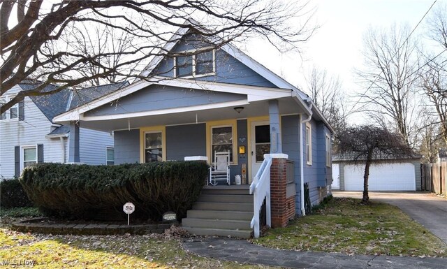view of front of property featuring an outbuilding, a porch, and a detached garage