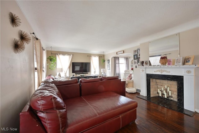 living room featuring a tiled fireplace and wood finished floors