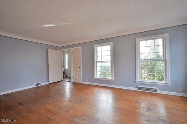 interior space featuring visible vents, wood-type flooring, and baseboards