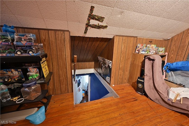 bedroom featuring hardwood / wood-style floors and wood walls