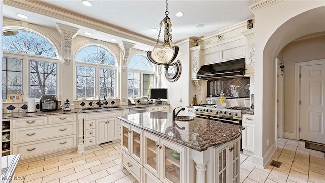 1524 Eagle Watch St NE, Canton, OH 44721 - kitchen with range hood, dark stone countertops, arched walkways, a sink, and glass insert cabinets