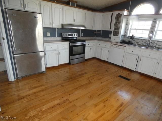 11380 Valley Dr, The Plains, OH 45780 - kitchen with light wood-style flooring, under cabinet range hood, a sink, white cabinetry, and stainless steel appliances
