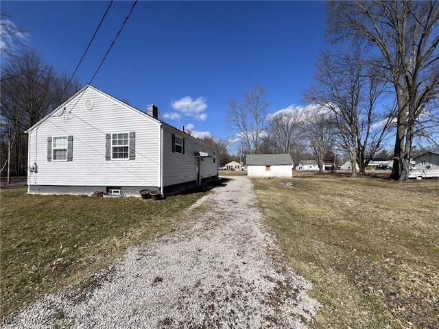 1865 Triumph Ave, Lake Milton, OH 44429 - view of home's exterior with an outbuilding, driveway, a chimney, and a yard