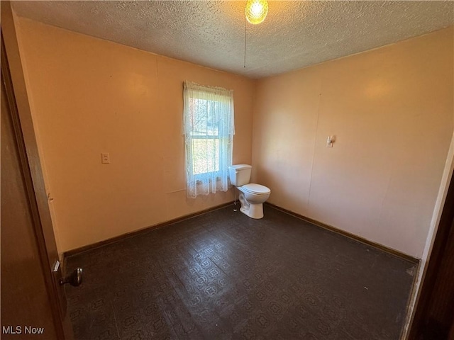 interior space with baseboards and a textured ceiling