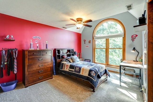 carpeted bedroom featuring visible vents, lofted ceiling, a textured ceiling, and a ceiling fan