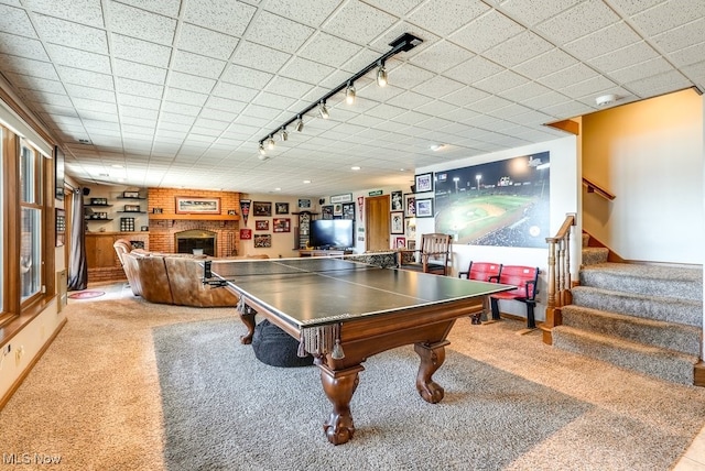 recreation room featuring track lighting, a brick fireplace, pool table, baseboards, and carpet