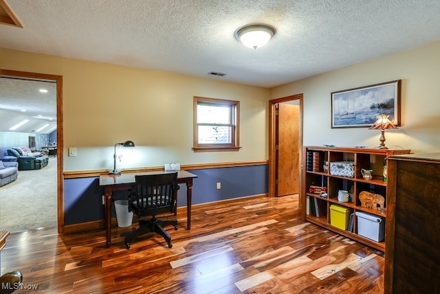 home office with visible vents, a textured ceiling, and wood finished floors