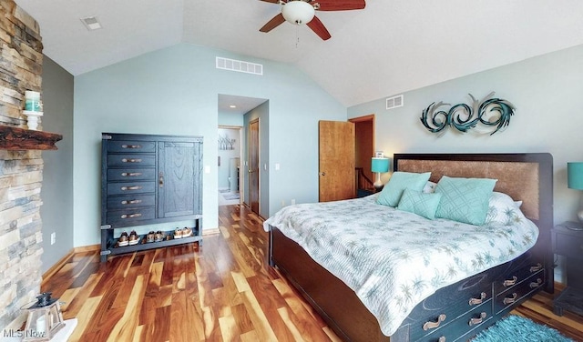 bedroom with ceiling fan, visible vents, lofted ceiling, and wood finished floors