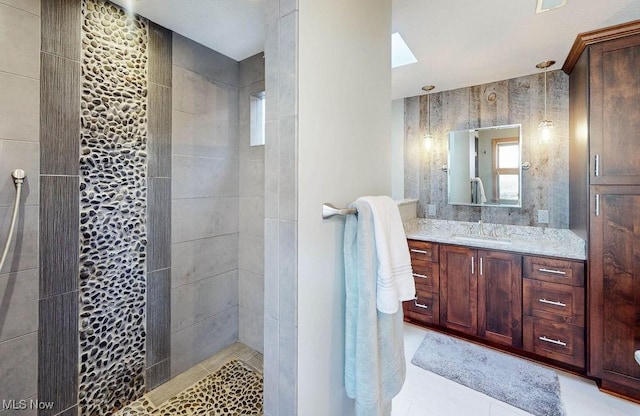 full bathroom with a skylight, vanity, and walk in shower