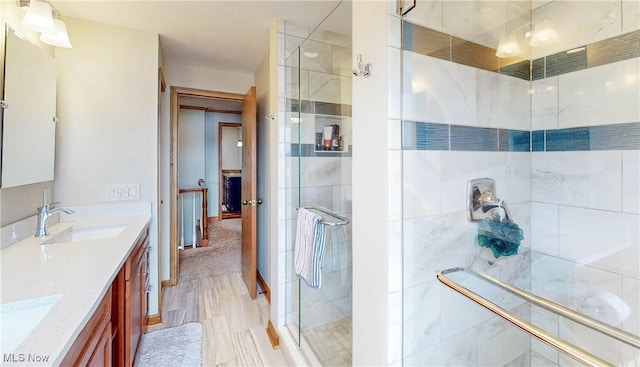 full bath featuring a shower stall, double vanity, and a sink