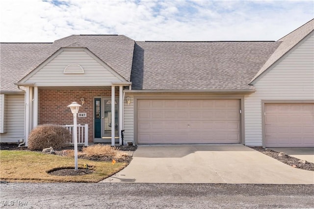 view of front of home featuring concrete driveway, a garage, and a shingled roof
