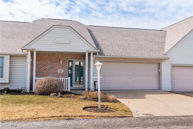 view of front of home with an attached garage, brick siding, driveway, and a shingled roof