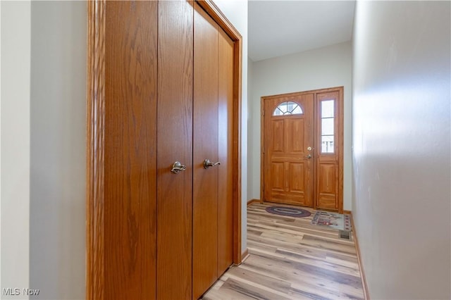 doorway to outside featuring baseboards and light wood-type flooring