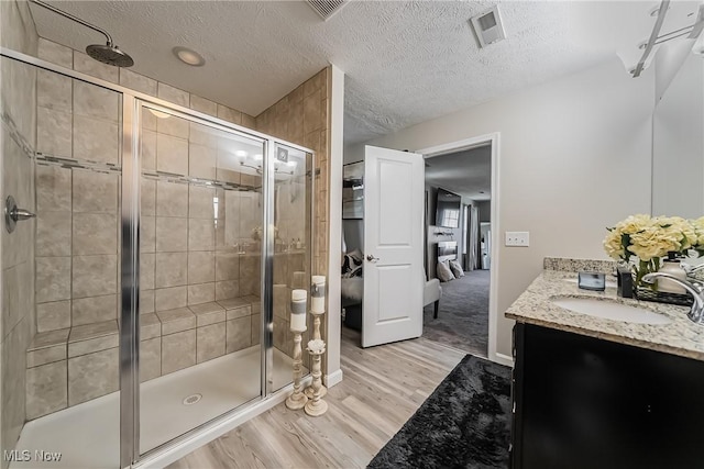 784 Hilliary Ln, Aurora, OH 44202 - full bath featuring wood finished floors, a stall shower, vanity, ensuite bath, and a textured ceiling