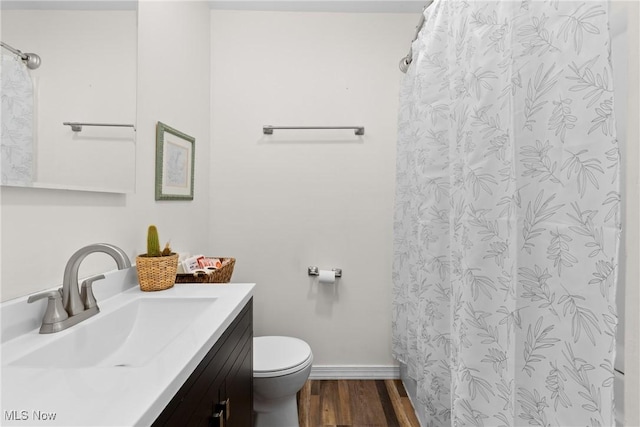 bathroom featuring a shower with shower curtain, toilet, vanity, wood finished floors, and baseboards