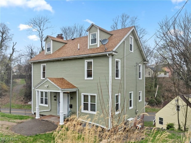 view of front of property with a chimney and a shingled roof