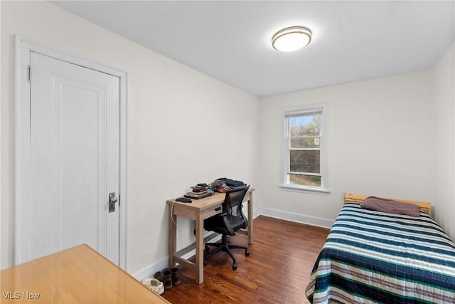 bedroom with dark wood finished floors and baseboards
