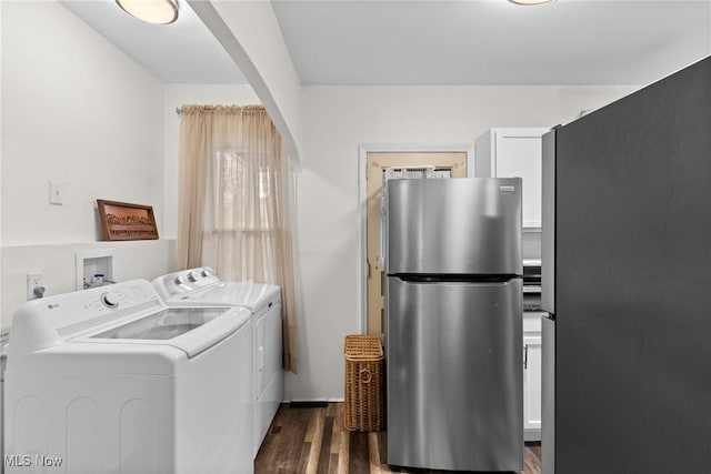 clothes washing area with dark wood-style flooring, arched walkways, laundry area, and washing machine and clothes dryer