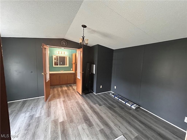 78790 Hamilton Ridge Rd, Freeport, OH 43973 - spare room with wood finished floors, a textured ceiling, lofted ceiling, and a chandelier