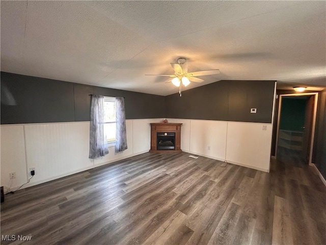 78790 Hamilton Ridge Rd, Freeport, OH 43973 - unfurnished living room featuring a textured ceiling, a ceiling fan, dark wood-type flooring, a fireplace, and lofted ceiling