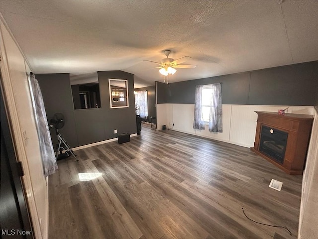 78790 Hamilton Ridge Rd, Freeport, OH 43973 - unfurnished living room featuring a ceiling fan, lofted ceiling, wood finished floors, a textured ceiling, and a glass covered fireplace
