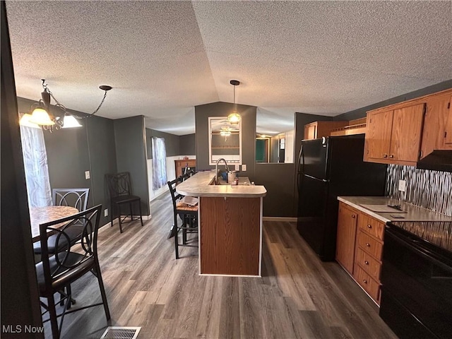 78790 Hamilton Ridge Rd, Freeport, OH 43973 - kitchen featuring black appliances, light countertops, a breakfast bar, dark wood-style floors, and a textured ceiling