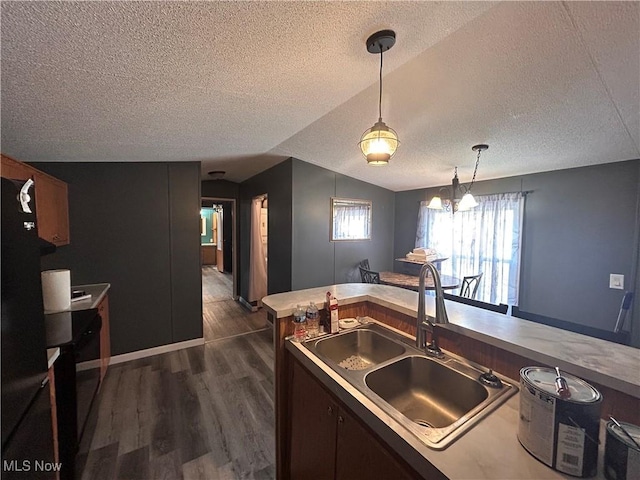 78790 Hamilton Ridge Rd, Freeport, OH 43973 - kitchen with a textured ceiling, vaulted ceiling, dark wood-style floors, hanging light fixtures, and light countertops