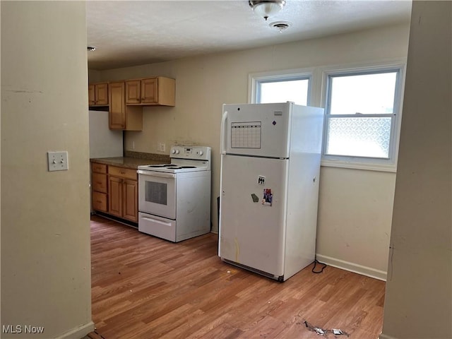 244 E 238th St, Euclid, OH 44123 - kitchen featuring white appliances, light wood finished floors, baseboards, light brown cabinetry, and dark countertops