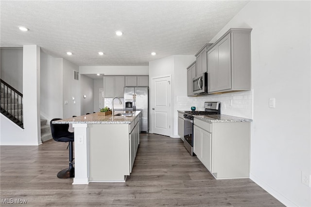 kitchen with visible vents, gray cabinetry, a sink, and appliances with stainless steel finishes