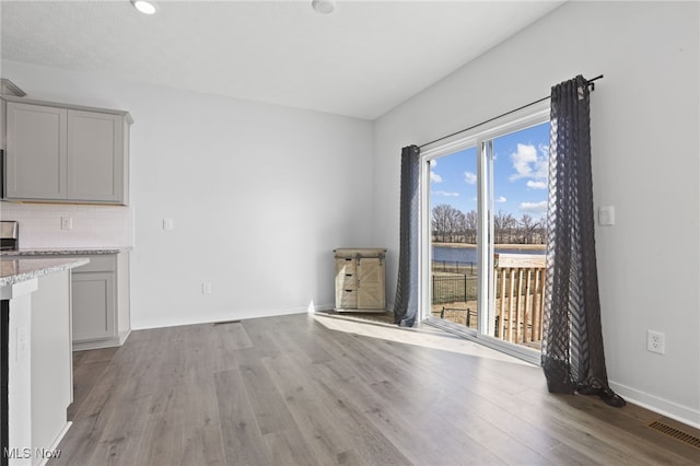 unfurnished dining area featuring recessed lighting, baseboards, visible vents, and light wood-style flooring