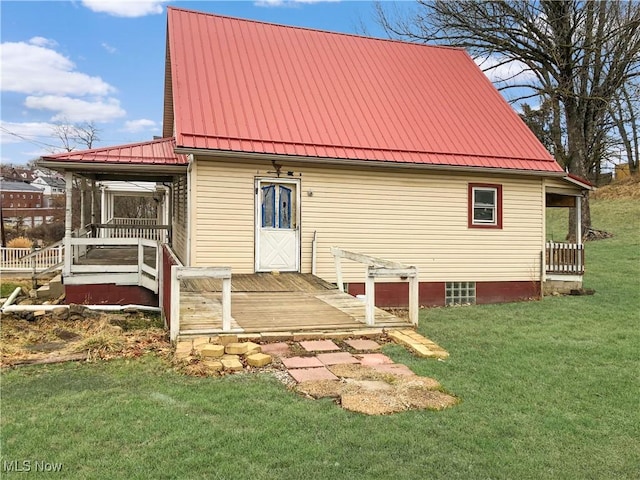 rear view of house featuring metal roof and a lawn