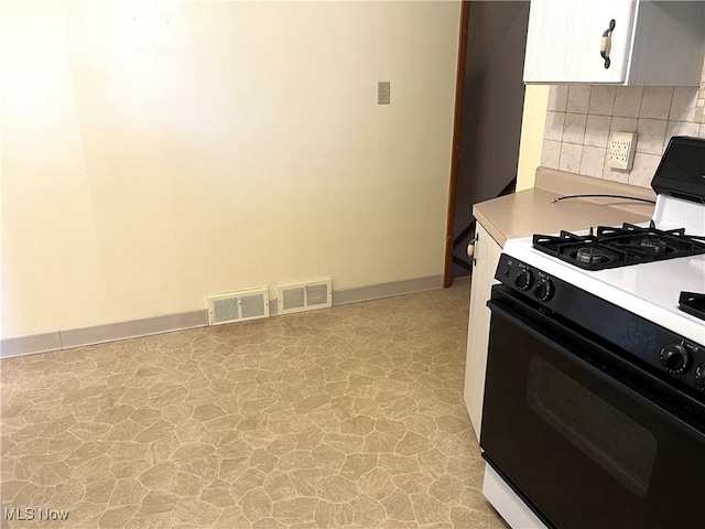 kitchen with visible vents, tasteful backsplash, gas range oven, and light countertops