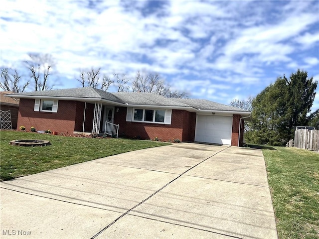 single story home featuring a front yard, an attached garage, brick siding, and driveway